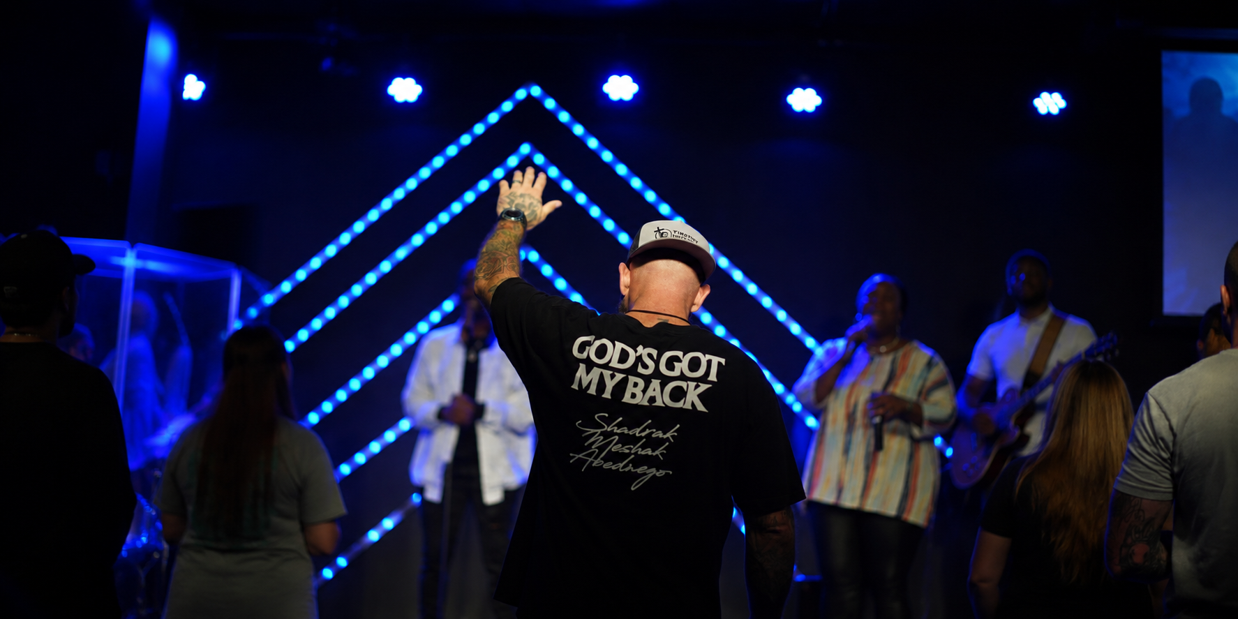 Kairos Church worship service with hands raised toward the stage