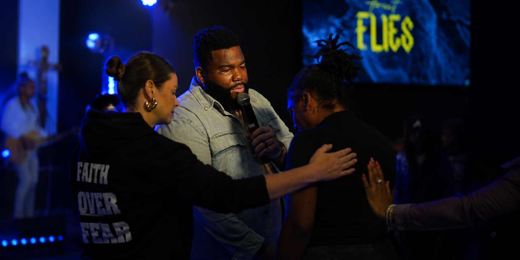 Pastor Sheldon Harris praying over people during a Kairos service